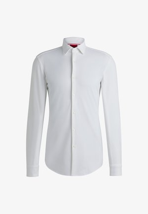Chemise blanche à manches longues avec un col évasé, patte de boutonnage à l'avant et ourlet arrondi. Fabriquée dans un tissu lisse avec un léger éclat.