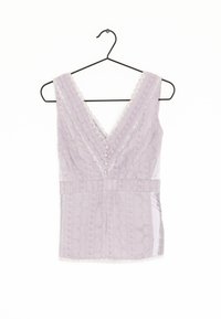Lavender tank top with a deep V-neck, textured fabric, lace trim, front button details, and a fitted waist. Hangs from a black hook.