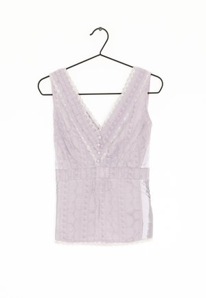 Lila Tanktop mit tiefem V-Ausschnitt, strukturierter Stoff, Spitzenbesatz, Knopfleiste vorne und tailliertem Schnitt. Hängt an einem schwarzen Haken.