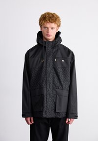 Mustmustel must jacket, millede mustrooriga upper paneeli, reguleeritava kapuutsi ja kuldse riistvaraga kaunistused. Omab suuri esipockets.