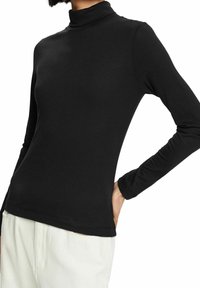 Svart långärmad polotröja i mjukt, stretchigt material med en åtsittande silhuett och slät yta. Inga mönster eller utsmyckningar.