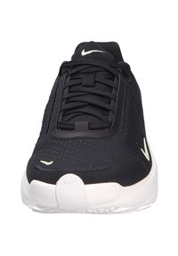 Sneakers Nike neri con tomaia testurizzata, suola bianca e dettagli giallo-verdi. Caratterizzati da lacci e design con punta arrotondata.