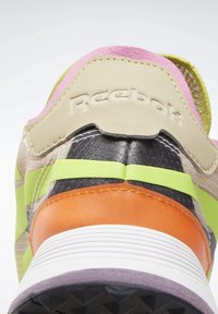 Baskets colorées Reebok présentant un mélange de matériaux texturés : daim rose, accents verts, mesh noir et détails orange vifs.
