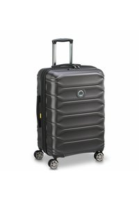Maleta rígida de color gris oscuro con diseño acanalado, asa retráctil, cuatro ruedas giratorias y cierre de cremallera. Presenta un logotipo circular.