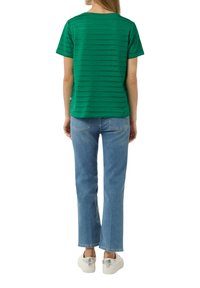 Green striped t-shirt with a relaxed fit, short sleeves, and a round neckline, paired with light blue straight-leg jeans and white sneakers.