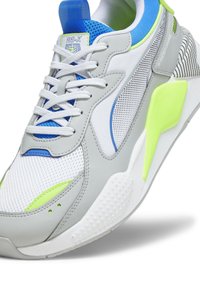 Šedá síťovaná teniska s modrými a neonově zelenými akcenty. Obsahuje strukturovanou podrážku, polstrovaný límec a detailní prošívání. Viditelné logo RS-X.