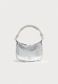 Bolsa metálica prateada com uma superfície texturizada, forma curva, alça de corrente e detalhes em alça de tecido atada. Fecho com zíper.