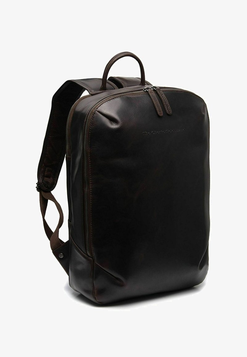 Sac à dos en cuir marron avec une texture lisse, en forme rectangulaire, poignée supérieure, bretelles réglables et accents de zip en métal.