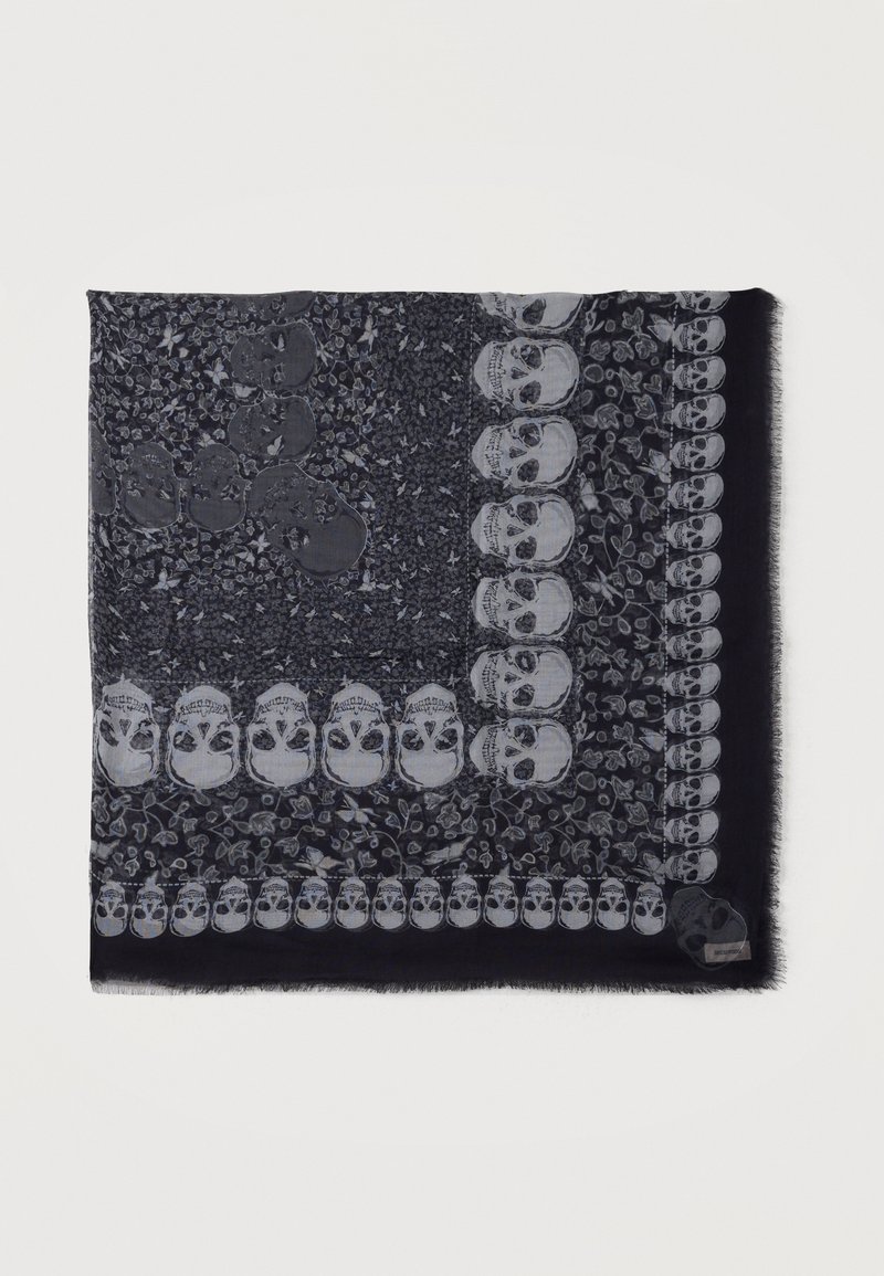 Σκούρο κασκόλ με σχέδιο φωτεινών κρανίων και ανθικών μοτίβων διατεταγμένα σε ένα τετράγωνο περίγραμμα.