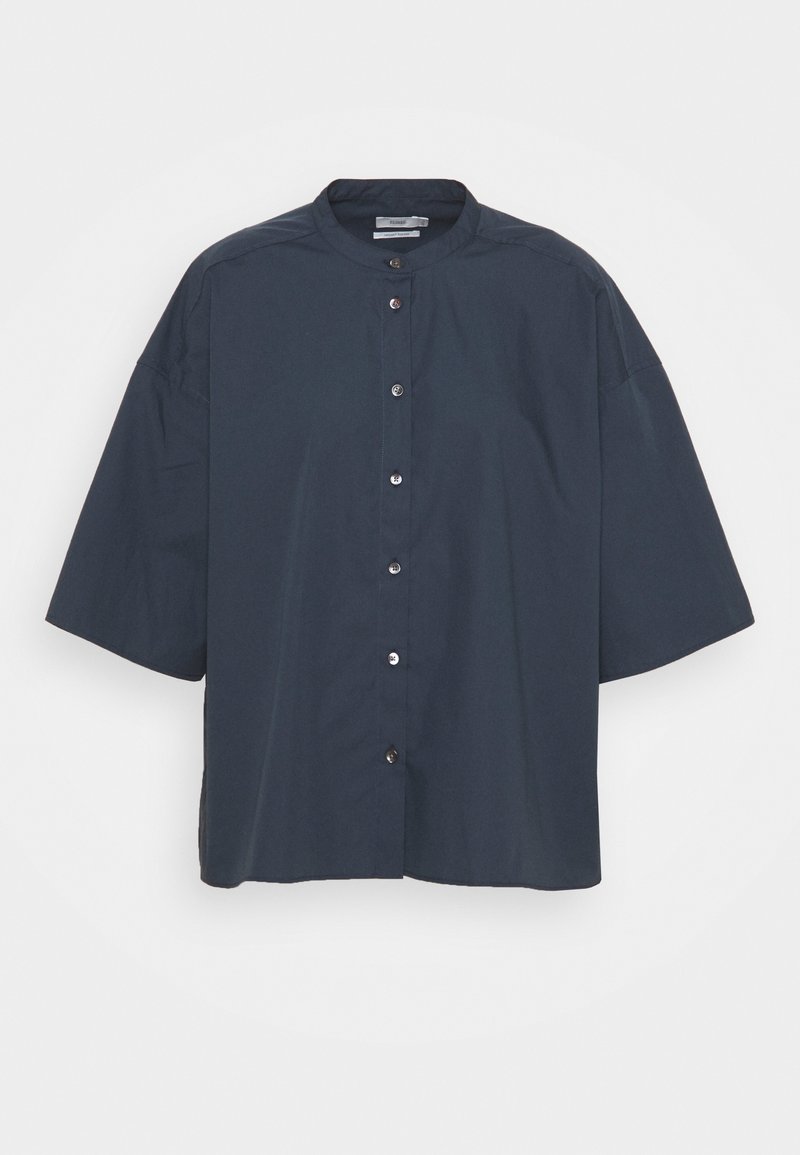 Chemise bleu foncé à manches courtes avec boutons, col rond et coupe ample, présentée sur un fond clair uni.