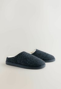 Tmavě modré pletené pantofle s texturovaným textilním povrchem, měkkým bílým podšívkou a černou gumovou podrážkou. Design na klouzání bez zapínání.