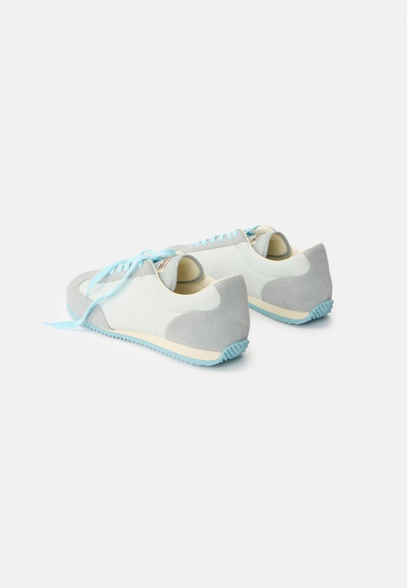 Coppia di sneakers casual bianche e grigio chiaro con lacci e suole azzurri, viste da dietro in prospettiva a tre quarti su sfondo uniforme.