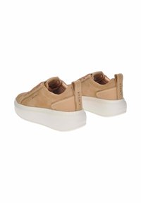 Un paio di sneaker in suede beige con suole bianche spesse, design con lacci e linguette sul tallone con il marchio "SMITH".