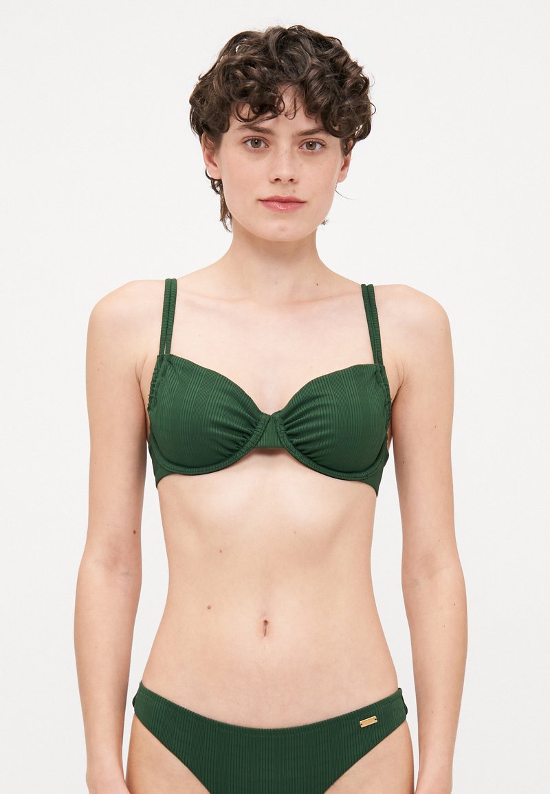 Mørk grønn bikinitopp med ribbet tekstur, undertrådstøtte og justerbare stropper, med en subtil gullaccent på bunnen.