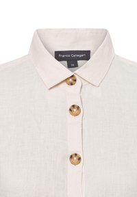 Lichtbeige linnen shirt met een kraag, voorzien van drie grote ronde knopen in een donkere tint en een label met de tekst "Franco Callegari."