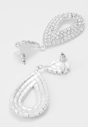 Paire de boucles d'oreilles pendantes ton argent avec des formes en goutte incrustées de petits strass transparents et fermoirs à poussette avec arrêts transparents.