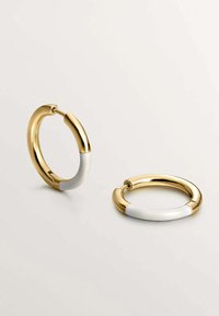 Pendientes de aro tono dorado con una banda de acento blanca. Forma circular, acabado brillante y cierre de bisagra para poner y quitar fácilmente.