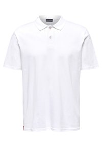 Hvid polo-shirt lavet af bomuld, med en klassisk krave, to-knaps placket og et lille mærketag på kanten. Korte ærmer.