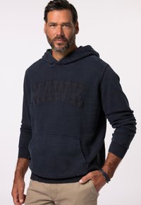 Námořnický modrý mikina vyrobená z bavlněné směsi má klokaní kapsu, žebrované manžety a velké embosované logo "HAWK" na přední straně.