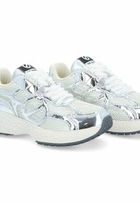 Baskets en mesh blanches avec des accents argentés, dotées d'une semelle texturée, de lacets et d'un logo sur la languette, alliant des éléments de design modernes.