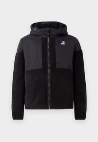 Veste noire avec capuche, présentant des manches et des panneaux en polaire texturée contrastante. Fermeture éclair à l'avant, deux poches poitrine et accent de logo de marque.