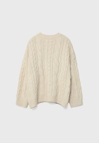 Kermaavärinen palmikkoneulepusero, jossa on pyöreä pääntie, ylisuurikokoinen istuvuus ja resorireunukset, esitellen teksturoitua, paksua neulekuviota.