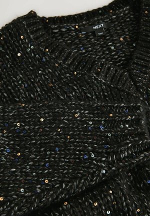 Black chunky knit sweater with multicolored sequins and ribbed neckline, folded to show texture and fabric details.