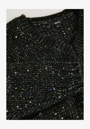 Mustat paksut neuleet, joissa on monivärisiä paljetteja ja ribbauskaula-aukko, taitettuna näyttämään tekstuuria ja kankaan yksityiskohtia.