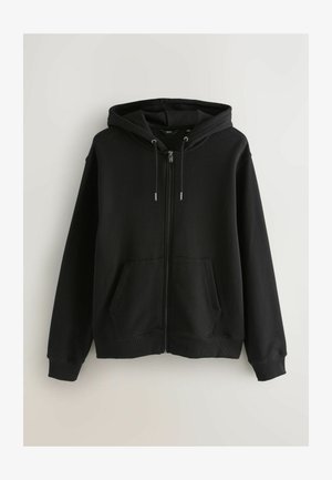 Melna kapucīna jaka ar rāvējslēdzēju, izgatavota no kokvilnas maisījuma, ar kapuci, priekšējām kabatām un ribota tipa aprocēm un apakšmalu. Gluda tekstūra, ikdienišķs dizains.