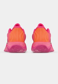 Jasnoróżowe buty sportowe z teksturowanym, falistym wzorem. Posiadają warstwowy materiał w kolorze różowym i pomarańczowym, amortyzowaną podeszwę oraz gumową antypoślizgową podeszwę.