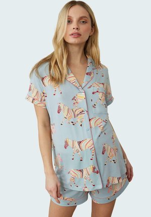 Ensemble de pyjama bleu clair comprenant une chemise à manches courtes et un short, orné de motifs de zèbres rayés colorés et d'accents roses.