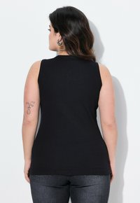 Top senza maniche nero in tessuto a costine, design aderente, texture liscia, con scollatura arrotondata e orlo leggermente curvato.