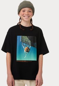 Camiseta de algodón negra con un gráfico colorido de baloncesto, con un diseño de red de malla. Corte relajado con mangas cortas y cuello redondo.