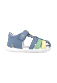 Sandalia de cuero azul con tiras de velcro, diseño abierto, rayas coloridas en verde, amarillo y blanco, con una suela blanca perforada.