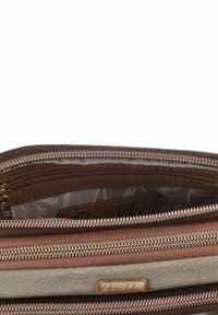 Braune Geldbörse mit mehreren Reißverschlüssen, die eine strukturierte Außenseite, ein glattes Innenfutter und ein Logo in Goldoptik aufweist. Enthält mehrere Fächer zur Aufbewahrung.