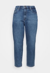 Jeans z indigo niebieskiego denimu z wysokim stanem, zwężającymi się nogawkami i pięcioma kieszeniami. Posiadają zapięcie na guziki z przodu oraz delikatne przetarcia.