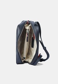 Borsa a tracolla in pelle navy con chiusura con zip, fodera interna crema con un motivo e tracolla regolabile.