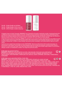 Deux flacons de vernis à ongles étiquetés « once in a berry » rouge et « clear high shine top coat » blanc sur fond rose avec texte d'utilisation et de sécurité.