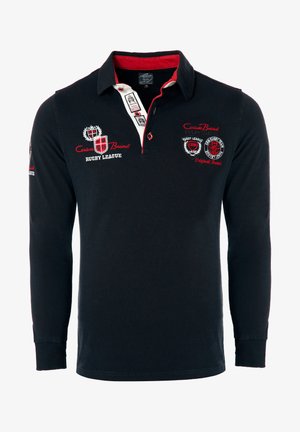 Koszulka rugby z długim rękawem w granatowym kolorze, wykonana z bawełny, z czerwonym kołnierzykiem. Posiada haftowane logo oraz tekst na szyi i rękawach. Regularny krój.