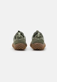 Zapatillas deportivas verdes con una suela de goma marrón texturizada. Cuentan con un cuello acolchado y una pestaña en el talón, así como paneles de malla transpirable para ventilación.