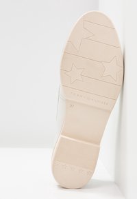 Semelle de chaussure pour femme, en caoutchouc crème avec motif à cinq étoiles, marque Tommy Hilfiger, taille 37. Sections de grip texturées, base lisse.