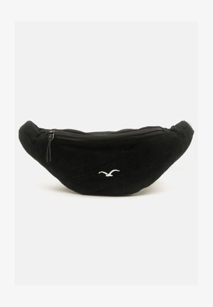 Black corduroy fanny pack with a rounded shape, zip closure on top, and a small white bird logo on the front.