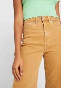 Hoge taille, rechte jeans in een lichtbruine kleur, gemaakt van denim. Voorzien van een paar zakken aan de voorkant, een knoopsluiting en subtiele stikdetails.