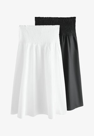 Zwei trägerlose Röcke mit gerafftem, elastischem Bund, einer vorne weiß und einer hinten schwarz, auf weißem Hintergrund.