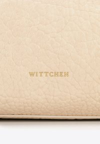 Sac à main en cuir beige avec une surface texturée. Présente le logo "WITTCHEN" embossé en doré. Bords lisses et design minimaliste.