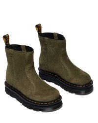 Botas de tornozelo em camurça verde-azeitona com sola de borracha preta, costura laranja e uma aba para fácil colocação. Design elegante com acabamento texturizado.