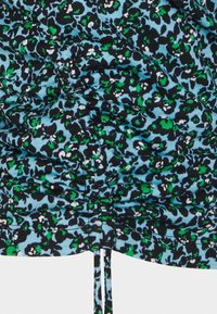 Mönstrad topp med en blå bakgrund som har svarta och gröna blommönster, texturerad tyg med rynkdetaljer och justerbar dragsko.