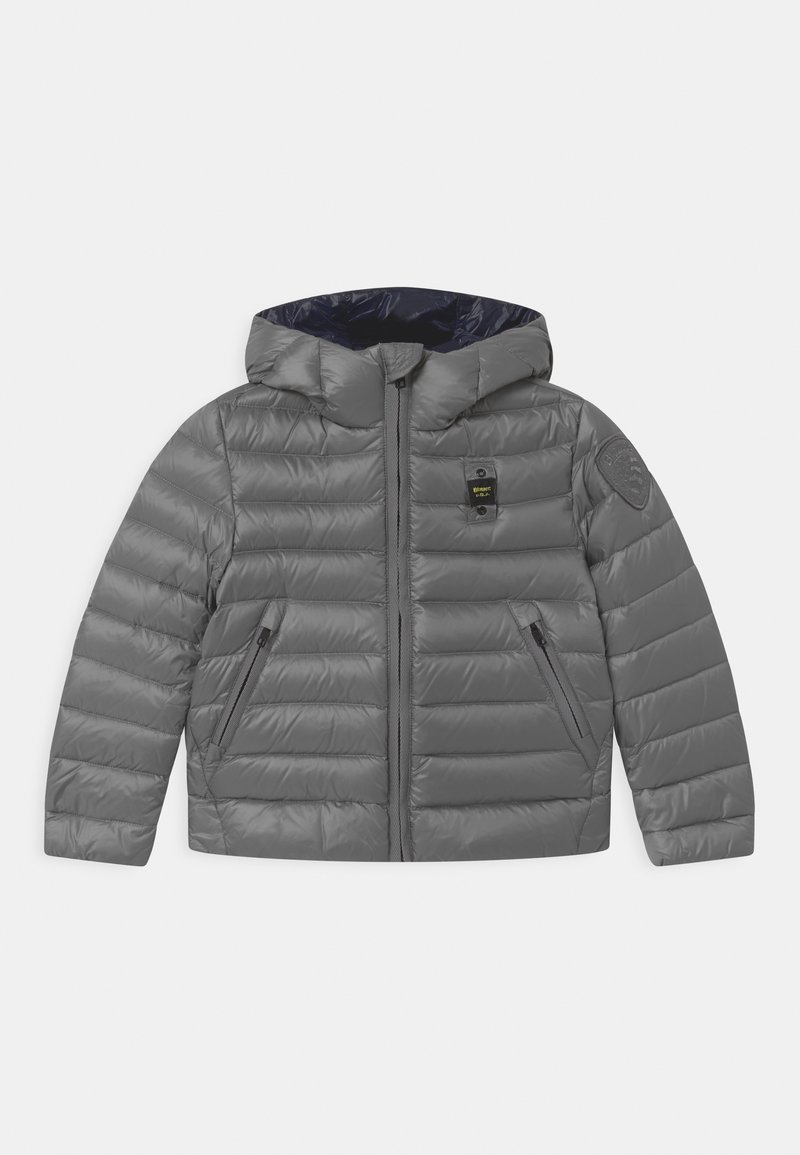 Veste matelassée grise avec capuche, présentant des coutures horizontales, des poches zippées et un logo sur la manche. L'intérieur est bleu marine.