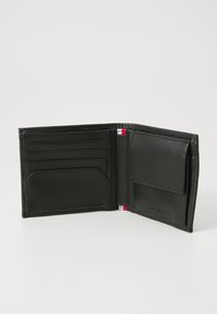 Portefeuille en cuir noir avec une finition texturée, doté de plusieurs emplacements pour cartes, d'une poche et de coutures d'accent rouge et blanc.