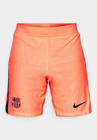 Narandžaste atletske šortse sa prugastom teksturom, sa tamnoplavim bočnim panelom, logotipom Barselone i Nike swoosh-om na donjem desnom delu.
